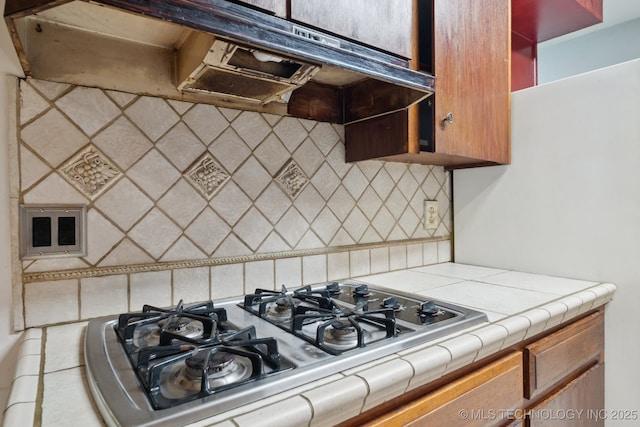 6922 E 16th St, Tulsa, OK 74112 - kitchen with tile counters, stainless steel gas cooktop, and decorative backsplash