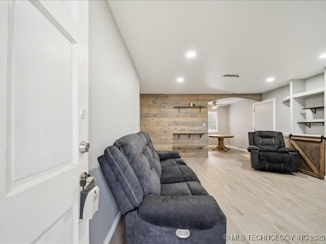 2346 S 118th E Ave, Tulsa, OK 74129 - living room featuring wooden walls, arched walkways, recessed lighting, and wood finished floors