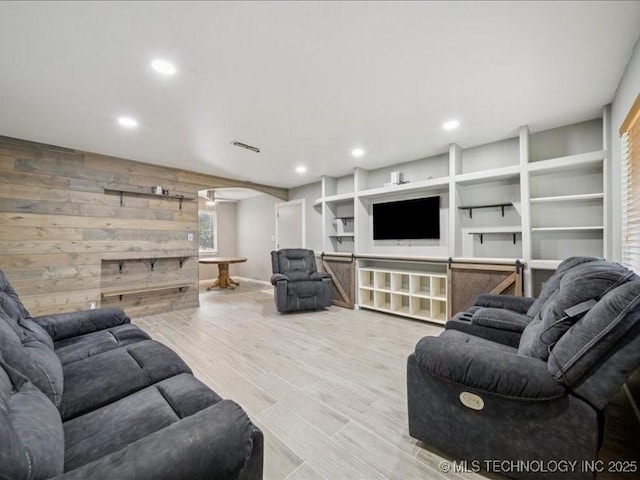 2346 S 118th E Ave, Tulsa, OK 74129 - living room featuring wooden walls, arched walkways, wood finished floors, recessed lighting, and built in shelves