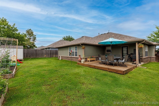 1113 S Spinnaker Dr, Oologah, OK 74053 - back of property with outdoor dining area, a fenced backyard, a deck, a storage unit, and a shingled roof