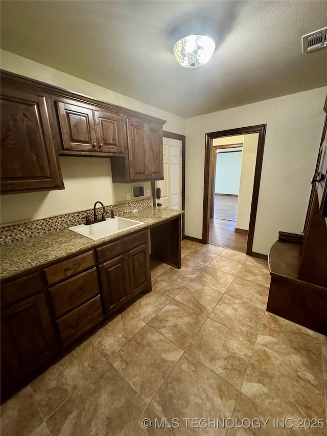 5510 Cooper Ct, Bartlesville, OK 74006 - kitchen with dark brown cabinetry and light tile patterned floors