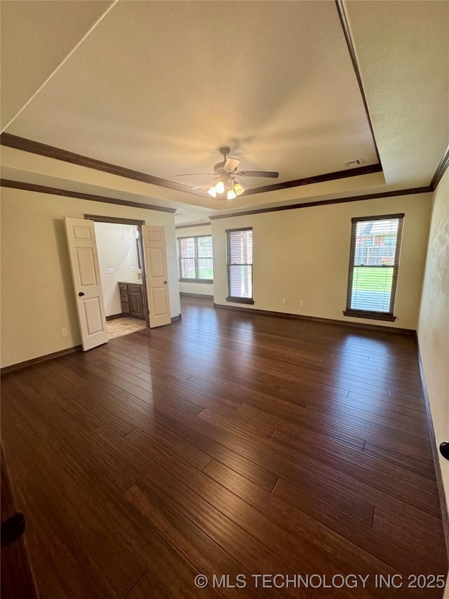 5510 Cooper Ct, Bartlesville, OK 74006 - spare room featuring ornamental molding, a ceiling fan, dark wood-type flooring, and a raised ceiling