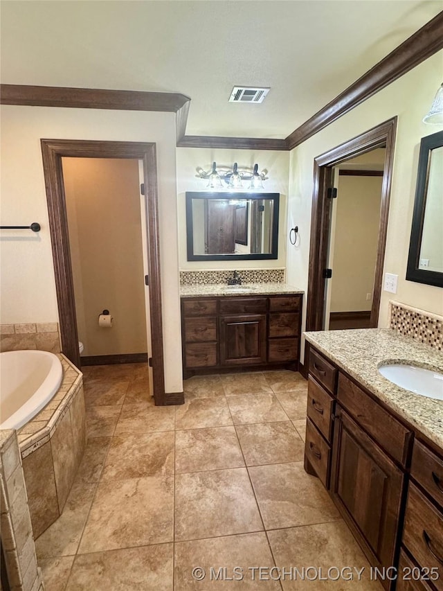 5510 Cooper Ct, Bartlesville, OK 74006 - bathroom featuring ornamental molding, a bath, two vanities, and tile patterned flooring
