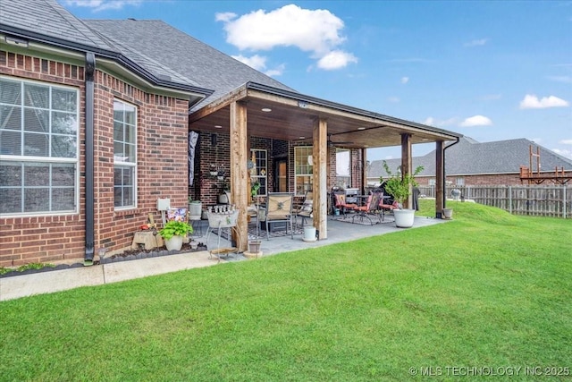 129 Highland Dr, Durant, OK 74701 - back of property with brick siding, a patio, and a shingled roof