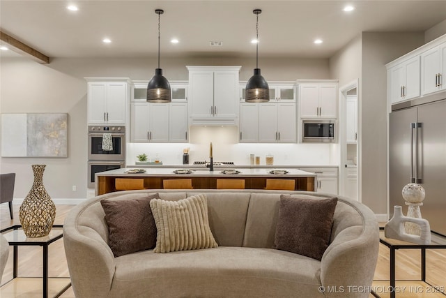4708 S Sequoia Ave, Broken Arrow, OK 74011 - kitchen featuring stainless steel appliances, recessed lighting, open floor plan, white cabinets, and a kitchen island with sink