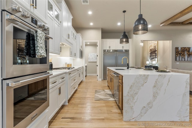 4708 S Sequoia Ave, Broken Arrow, OK 74011 - kitchen with appliances with stainless steel finishes, light wood finished floors, recessed lighting, white cabinetry, and decorative light fixtures