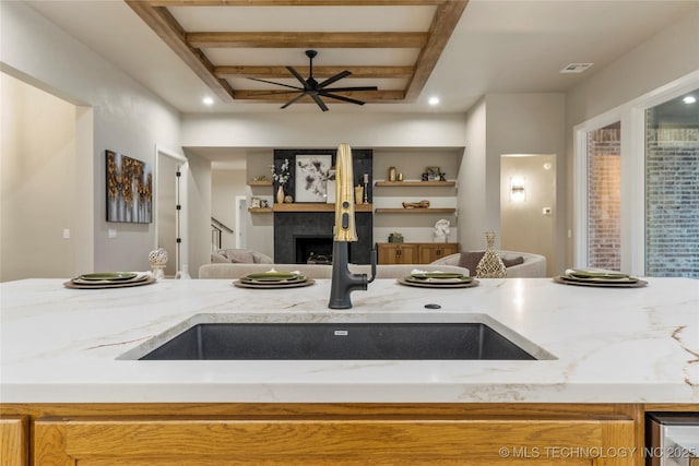 4708 S Sequoia Ave, Broken Arrow, OK 74011 - kitchen featuring light stone counters, a fireplace, beamed ceiling, and open floor plan