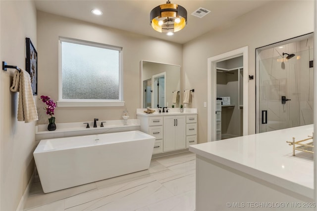 4708 S Sequoia Ave, Broken Arrow, OK 74011 - bathroom featuring a shower stall, a freestanding bath, vanity, a spacious closet, and marble finish floors
