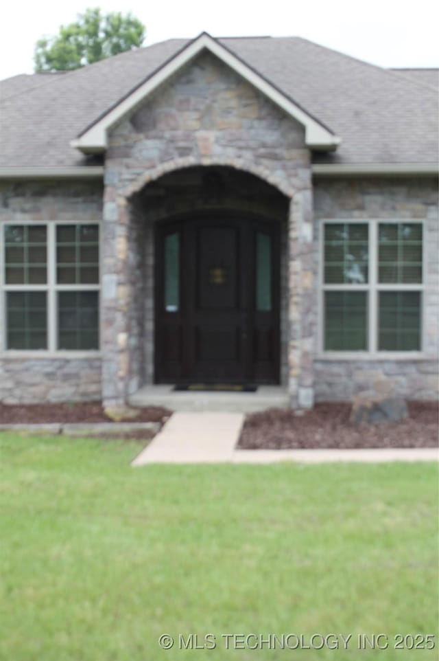 2148 E Wise Rd, Mcalester, OK 74501 - doorway to property with stone siding, a shingled roof, and a lawn