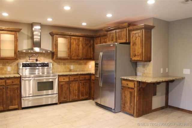 2148 E Wise Rd, Mcalester, OK 74501 - kitchen featuring wall chimney range hood, stainless steel appliances, tasteful backsplash, light stone counters, and recessed lighting