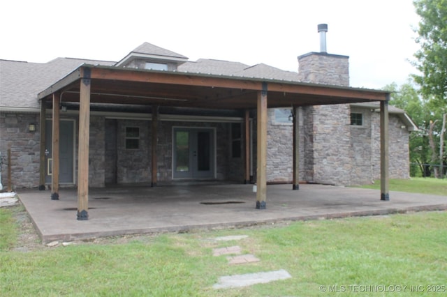 2148 E Wise Rd, Mcalester, OK 74501 - back of property with a chimney, a patio area, french doors, a yard, and stone siding