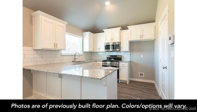 1441 E 149th Pl S, Glenpool, OK 74033 - kitchen featuring appliances with stainless steel finishes, a peninsula, wood finished floors, white cabinets, and tasteful backsplash