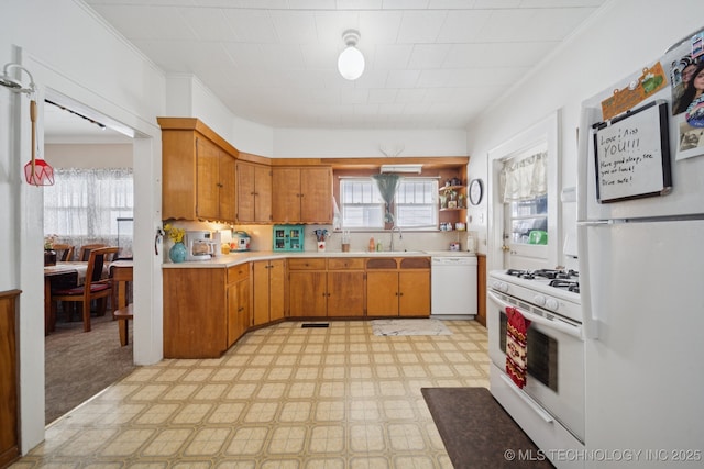 805 W Gentry St, Henryetta, OK 74437 - kitchen with white appliances, light floors, light countertops, brown cabinetry, and ornamental molding