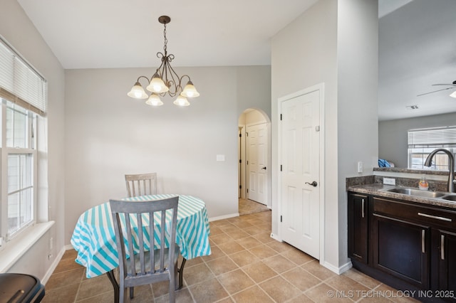 8661 S 264th E Ave, Broken Arrow, OK 74014 - dining room featuring arched walkways, a chandelier, light tile patterned floors, and a ceiling fan
