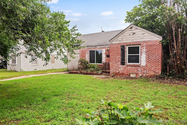 917 N Knoxville Ave, Tulsa, OK 74115 - view of front facade featuring a shingled roof, a front yard, and brick siding