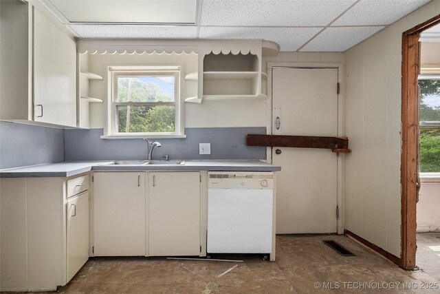 917 N Knoxville Ave, Tulsa, OK 74115 - kitchen featuring white dishwasher, open shelves, a paneled ceiling, light countertops, and decorative backsplash