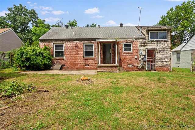 917 N Knoxville Ave, Tulsa, OK 74115 - back of property featuring a yard, a patio area, brick siding, and roof with shingles