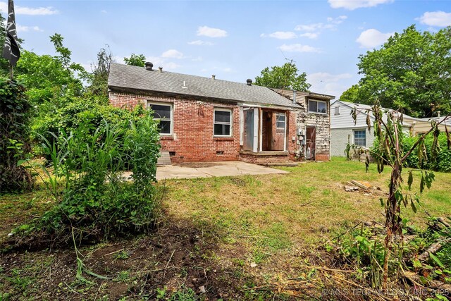 917 N Knoxville Ave, Tulsa, OK 74115 - back of property with brick siding, a patio area, a lawn, crawl space, and roof with shingles