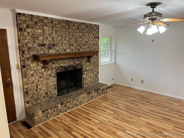 1918 E 14th, Ada, OK 74820 - unfurnished living room with wood finished floors, a ceiling fan, a fireplace, and ornamental molding