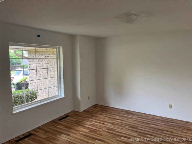 1918 E 14th, Ada, OK 74820 - spare room with wood finished floors and baseboards