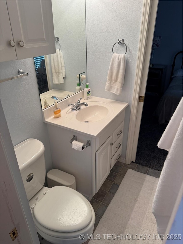 450779 E 341st Rd Unit 34, Afton, OK 74331 - ensuite bathroom with vanity, a textured wall, and tile patterned floors