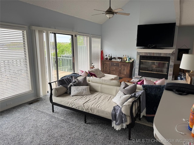 450779 E 341st Rd Unit 34, Afton, OK 74331 - carpeted living room featuring lofted ceiling, a ceiling fan, a tile fireplace, and a textured ceiling