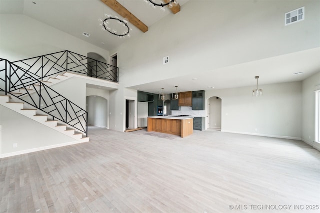 16817 E 41st Pl S, Tulsa, OK 74134 - unfurnished living room featuring arched walkways, high vaulted ceiling, light wood-style floors, a chandelier, and stairs