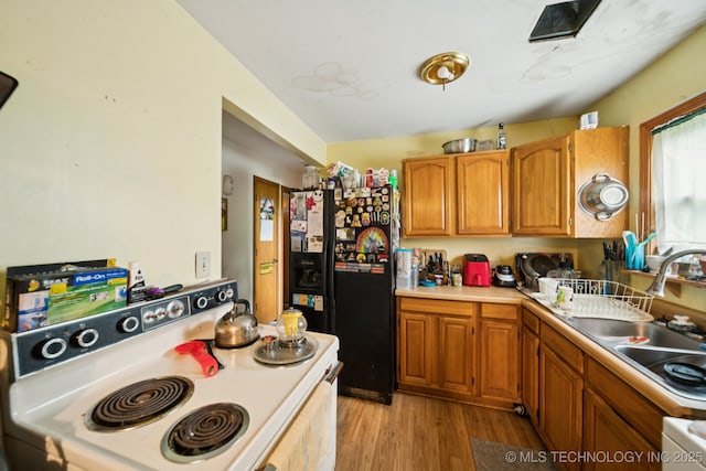 1012 N Irvington St, Tulsa, OK 74115 - kitchen featuring black fridge with ice dispenser, electric range, light countertops, and brown cabinets