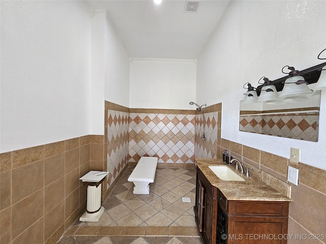 38032 State Road 78 W, Durant, OK 74701 - full bath with tile walls, vanity, a tile shower, tile patterned flooring, and wainscoting