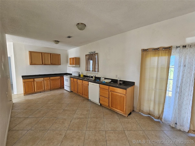 38032 State Road 78 W, Durant, OK 74701 - kitchen featuring white appliances, dark countertops, light tile patterned floors, a textured ceiling, and brown cabinets