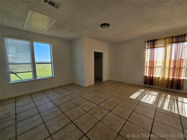 38032 State Road 78 W, Durant, OK 74701 - unfurnished room featuring attic access, light tile patterned floors, and a textured ceiling