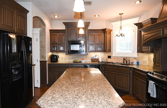 2463 S Park Hl, Tahlequah, OK 74464 - kitchen with black appliances, dark brown cabinets, backsplash, light stone counters, and a chandelier