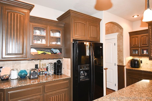 2463 S Park Hl, Tahlequah, OK 74464 - kitchen featuring black fridge, tasteful backsplash, glass insert cabinets, and light stone countertops