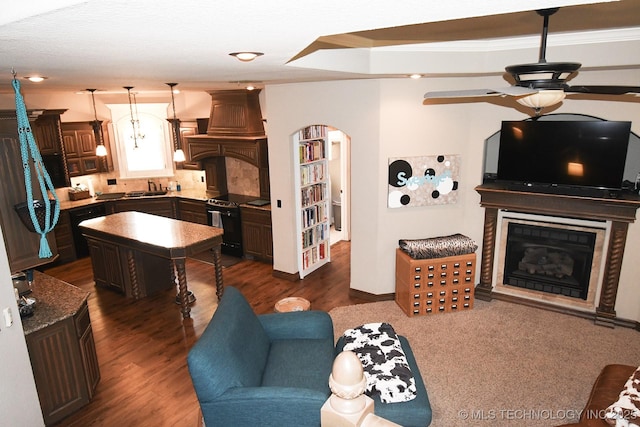 2463 S Park Hl, Tahlequah, OK 74464 - living room with ceiling fan, arched walkways, a fireplace with raised hearth, and dark wood-style floors