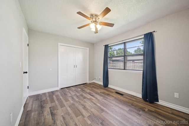 2331 S 99th E Ave, Tulsa, OK 74129 - unfurnished bedroom with wood finished floors, a textured ceiling, a closet, and a ceiling fan