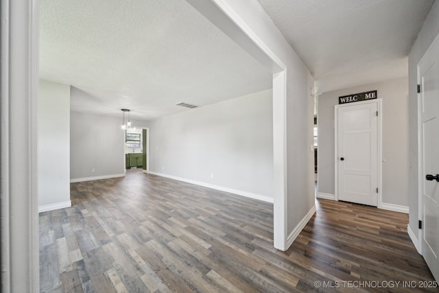 2331 S 99th E Ave, Tulsa, OK 74129 - empty room with a chandelier, dark wood-style floors, and a textured ceiling