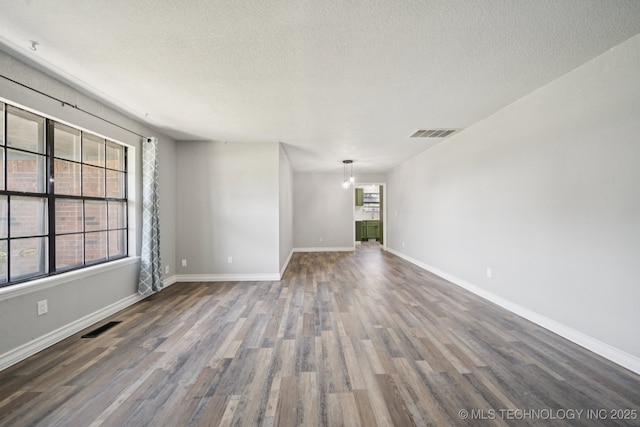 2331 S 99th E Ave, Tulsa, OK 74129 - spare room featuring wood finished floors and a textured ceiling