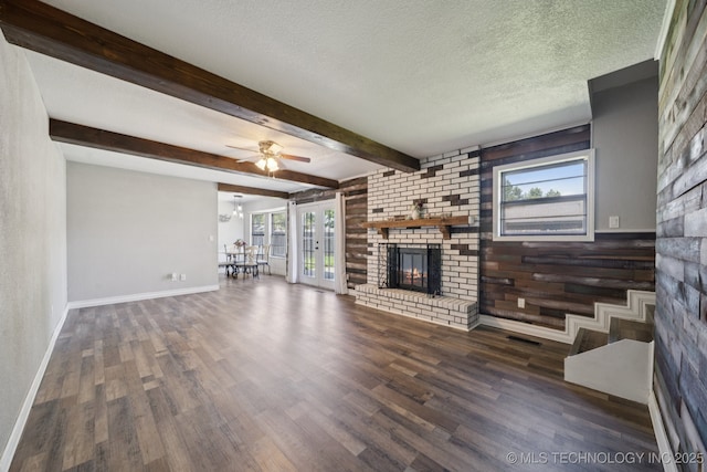 2331 S 99th E Ave, Tulsa, OK 74129 - unfurnished living room with a fireplace, plenty of natural light, wood finished floors, ceiling fan, and beam ceiling