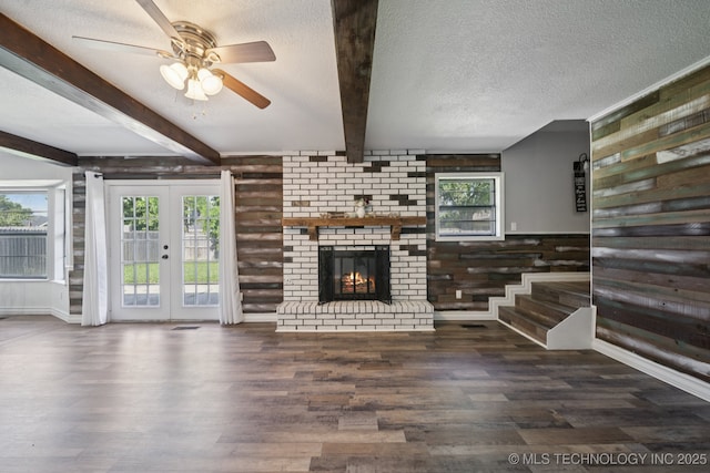 2331 S 99th E Ave, Tulsa, OK 74129 - unfurnished living room featuring wood finished floors, ceiling fan, beamed ceiling, a textured ceiling, and healthy amount of natural light