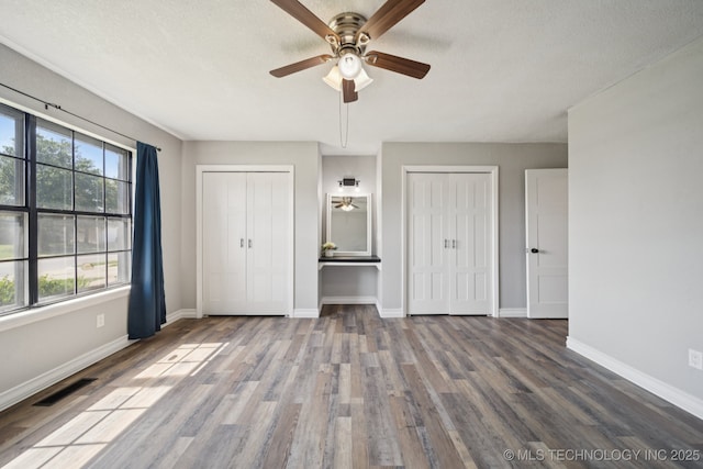 2331 S 99th E Ave, Tulsa, OK 74129 - unfurnished bedroom featuring multiple closets, wood finished floors, and ceiling fan