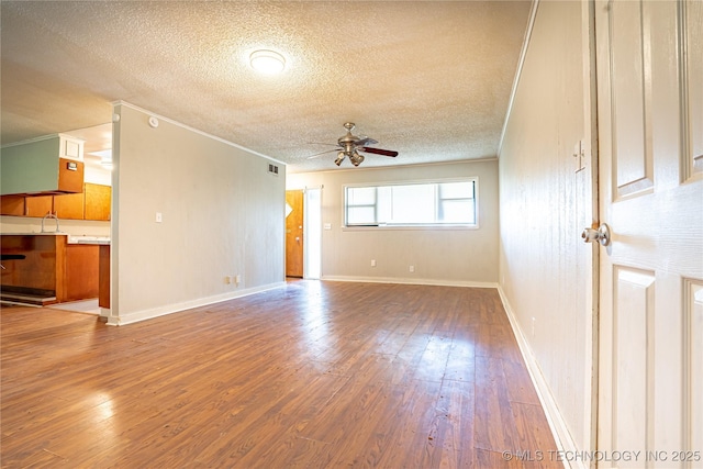 6781 E 26th Pl, Tulsa, OK 74129 - unfurnished living room featuring a textured ceiling, a ceiling fan, wood-type flooring, and ornamental molding