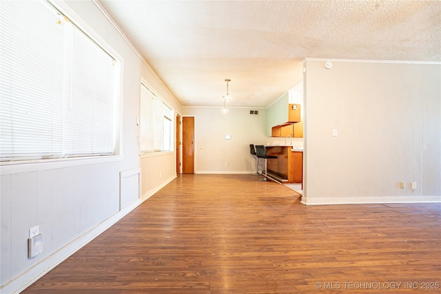 6781 E 26th Pl, Tulsa, OK 74129 - unfurnished living room featuring crown molding, wood finished floors, and a textured ceiling