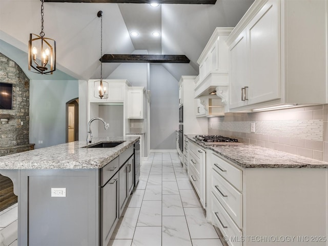 5815 E 144th St S, Bixby, OK 74008 - kitchen with light marble finish floors, arched walkways, stainless steel gas stovetop, light stone counters, and white cabinetry