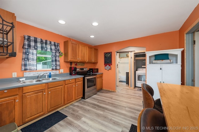6607 Old Taft Rd, Muskogee, OK 74401 - kitchen featuring stainless steel range with electric stovetop, washer / dryer, light wood-type flooring, recessed lighting, and brown cabinetry