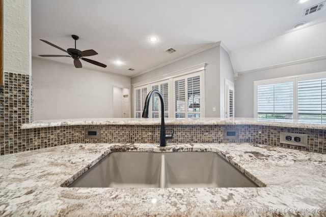 4205 N Narcissus Ave, Broken Arrow, OK 74012 - kitchen view of backsplash, light stone counters, recessed lighting, and a ceiling fan