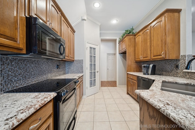 4205 N Narcissus Ave, Broken Arrow, OK 74012 - kitchen with black appliances, crown molding, light stone counters, light tile patterned floors, and brown cabinets
