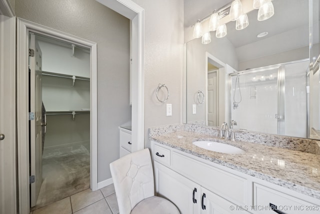 4205 N Narcissus Ave, Broken Arrow, OK 74012 - bathroom with a stall shower, tile patterned floors, vanity, and a walk in closet