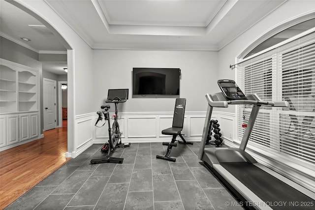 8905 N 137th E Ave, Owasso, OK 74055 - workout room featuring arched walkways, a raised ceiling, crown molding, a wainscoted wall, and built in shelves