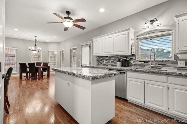 8905 N 137th E Ave, Owasso, OK 74055 - kitchen with stainless steel dishwasher, ceiling fan, backsplash, a kitchen island, and light wood-style floors