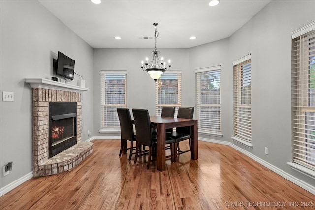8905 N 137th E Ave, Owasso, OK 74055 - dining area with a chandelier, wood finished floors, a fireplace, plenty of natural light, and recessed lighting